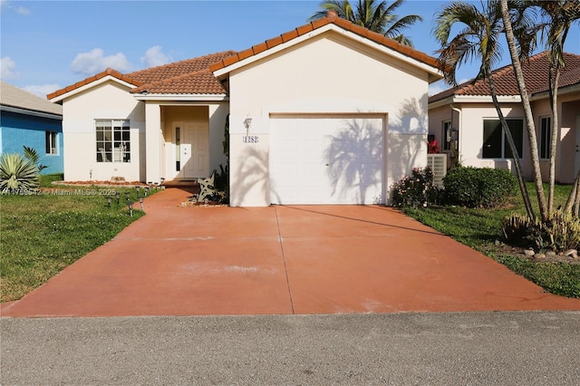 mediterranean / spanish home featuring a tile roof, a garage, driveway, and stucco siding