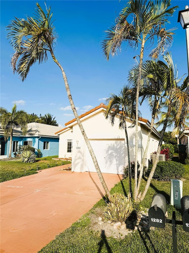 view of side of home featuring stucco siding, driveway, and a garage