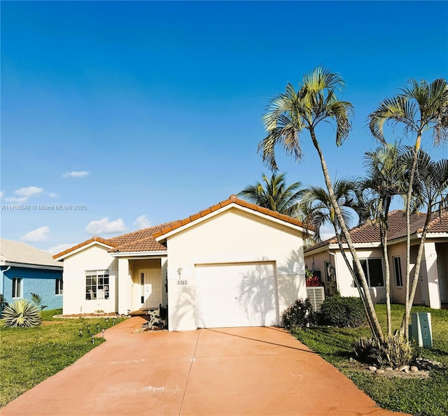 mediterranean / spanish-style house featuring a tiled roof, concrete driveway, a front yard, stucco siding, and a garage