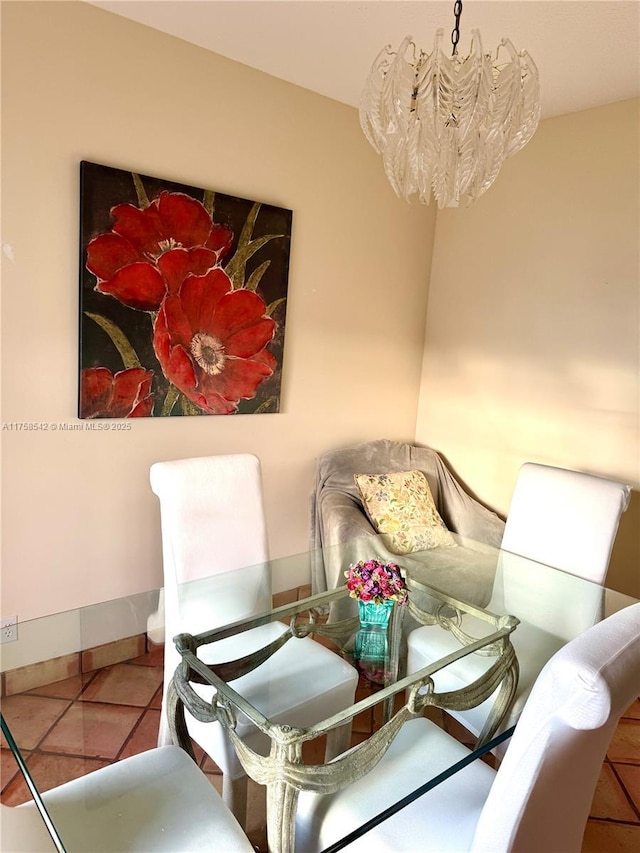 dining space with tile patterned flooring, a chandelier, and baseboards