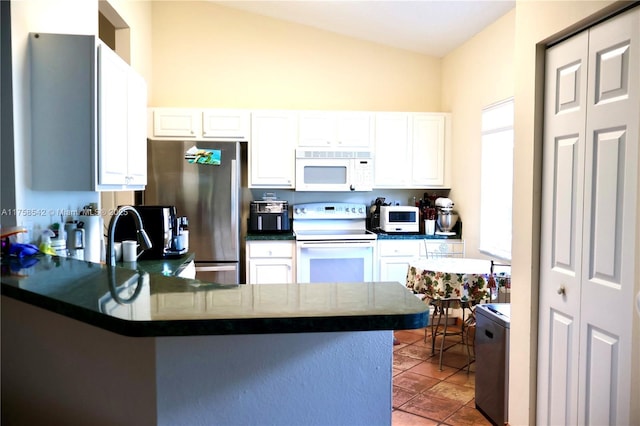 kitchen with white appliances, dark countertops, a peninsula, and white cabinetry