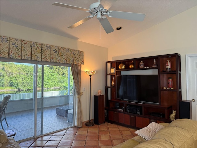 living room featuring vaulted ceiling, light tile patterned floors, and a ceiling fan