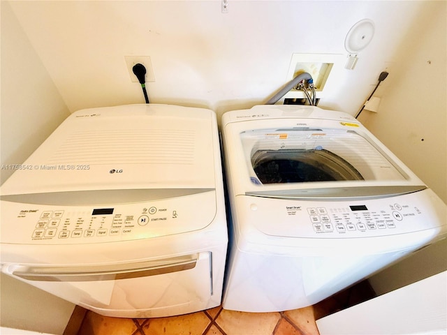 laundry room featuring laundry area, light tile patterned floors, and washing machine and clothes dryer