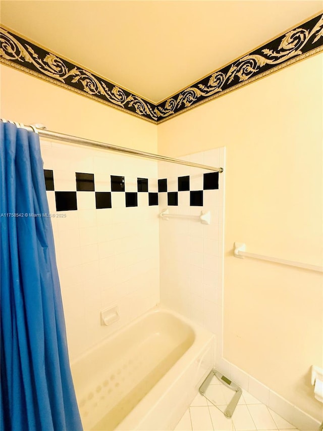 bathroom featuring tile patterned flooring, baseboards, and shower / bath combo