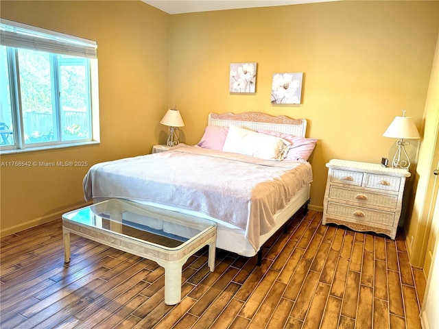 bedroom featuring wood finished floors and baseboards