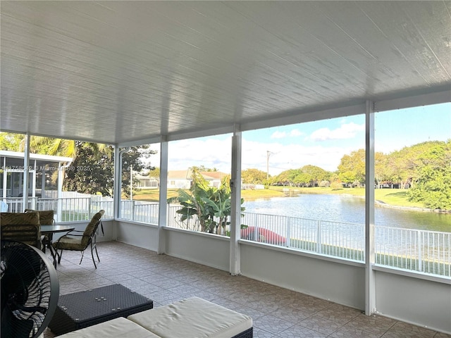 sunroom / solarium featuring a water view