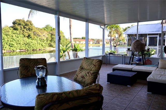 sunroom / solarium featuring a water view