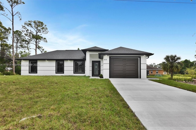 prairie-style house with a garage, stucco siding, driveway, and a front yard