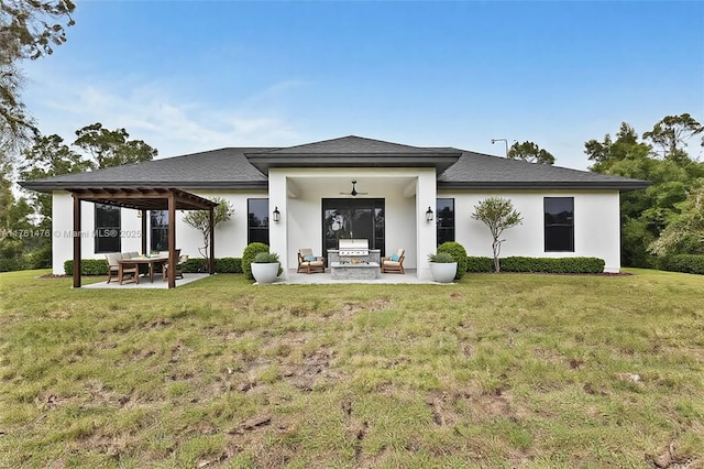 rear view of house featuring a patio area, stucco siding, and a yard