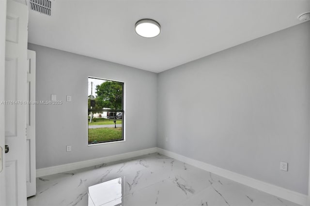 spare room with visible vents, baseboards, and marble finish floor