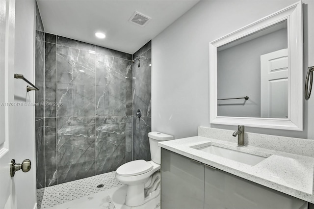 bathroom with visible vents, a shower stall, toilet, and vanity