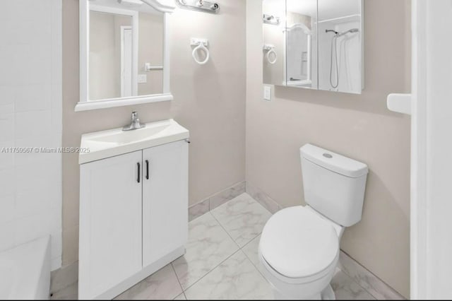 bathroom featuring vanity, toilet, baseboards, and marble finish floor