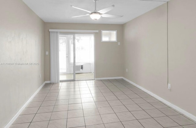 spare room featuring light tile patterned floors, baseboards, and ceiling fan