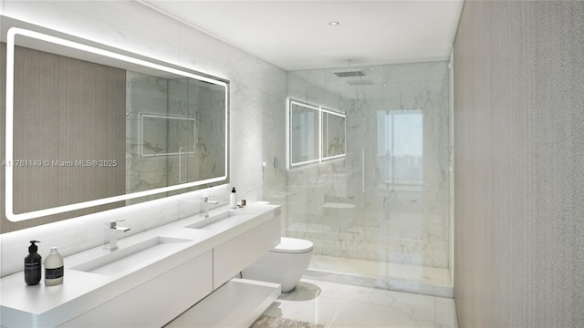 bathroom featuring a sink, a marble finish shower, and toilet