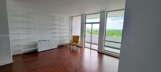 700 Biltmore Way Unit 1005, Coral Gables, FL 33134 - unfurnished room with wood finished floors, built in shelves, a wall of windows, and baseboards