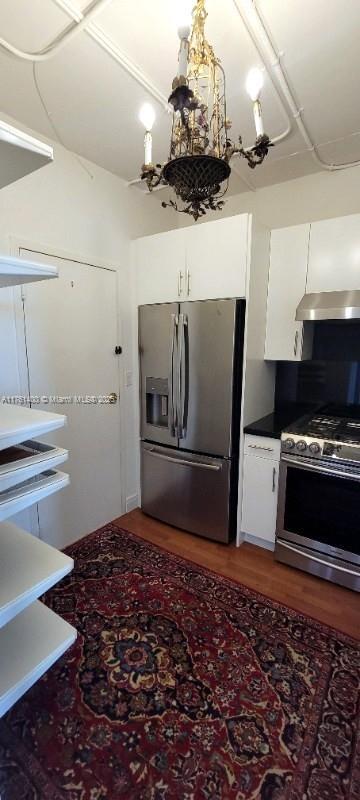 700 Biltmore Way Unit 1005, Coral Gables, FL 33134 - kitchen featuring stainless steel appliances, extractor fan, white cabinets, and wood finished floors