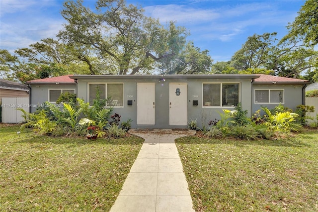 view of front of property with a front yard and stucco siding