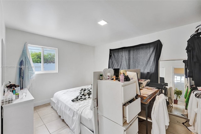 bedroom with light tile patterned floors and baseboards