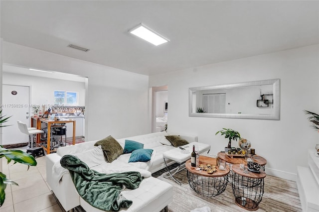 tiled living room with visible vents and baseboards