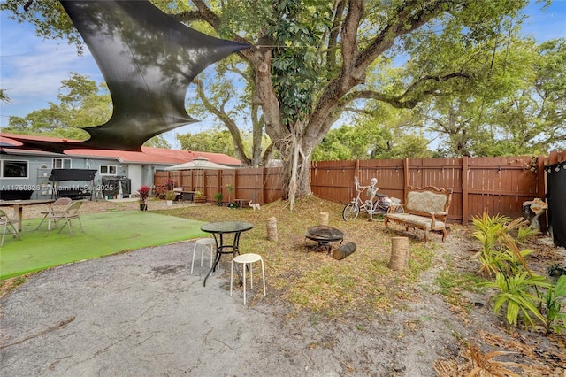 view of yard with a patio area, a fenced backyard, and an outdoor fire pit