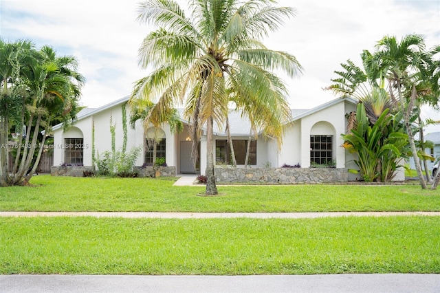 view of front of home with stucco siding and a front yard