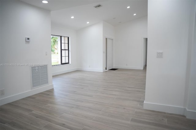 spare room with recessed lighting, visible vents, light wood finished floors, and baseboards