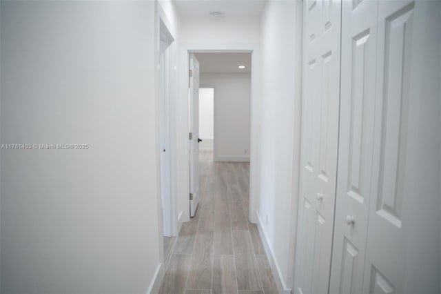 hall with recessed lighting, light wood-style floors, and baseboards