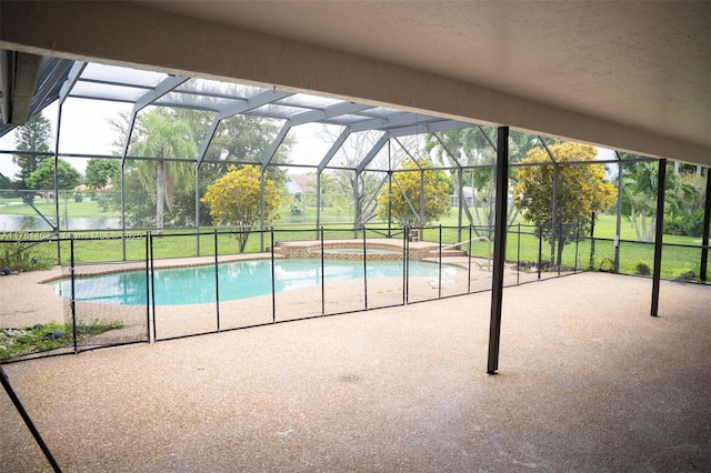 outdoor pool featuring glass enclosure, a yard, and a patio area