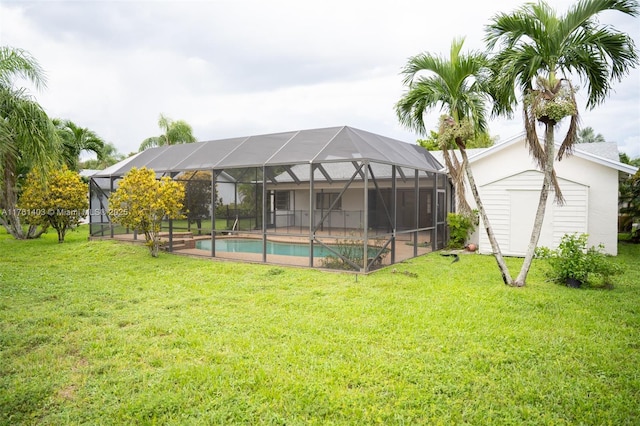 back of house with an outbuilding, a lawn, a shed, an outdoor pool, and a lanai