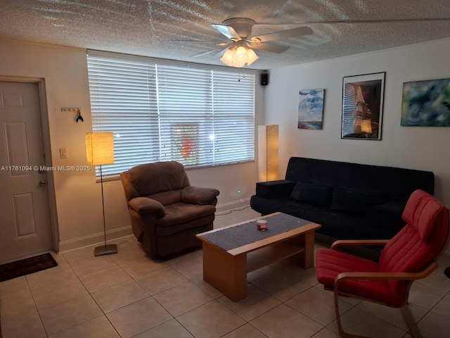 living room featuring light tile patterned floors, baseboards, a textured ceiling, and a ceiling fan