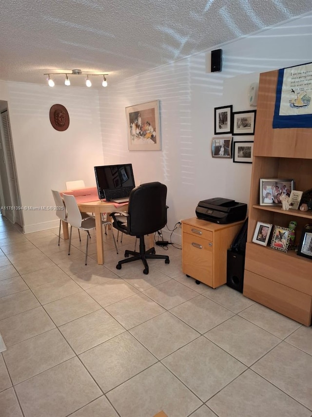 home office featuring light tile patterned flooring, rail lighting, and a textured ceiling