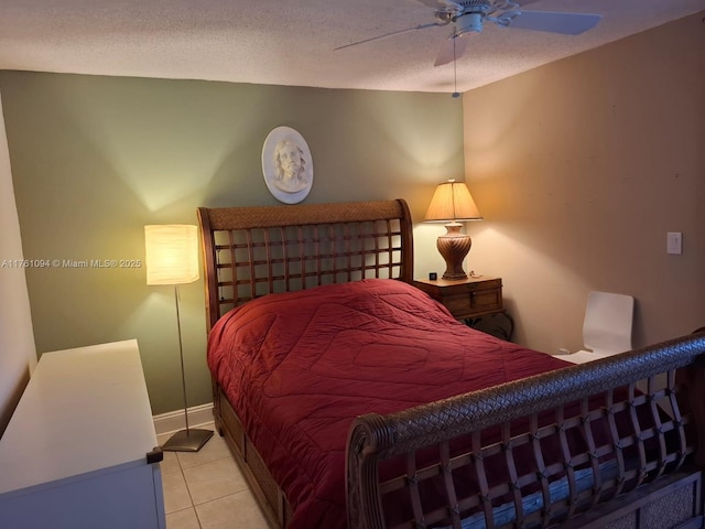 bedroom with ceiling fan, baseboards, a textured ceiling, and light tile patterned flooring