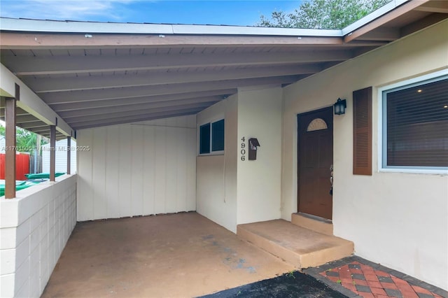 property entrance featuring an attached carport and stucco siding