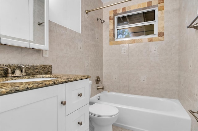 full bathroom featuring vanity, tile walls, toilet, and shower / washtub combination