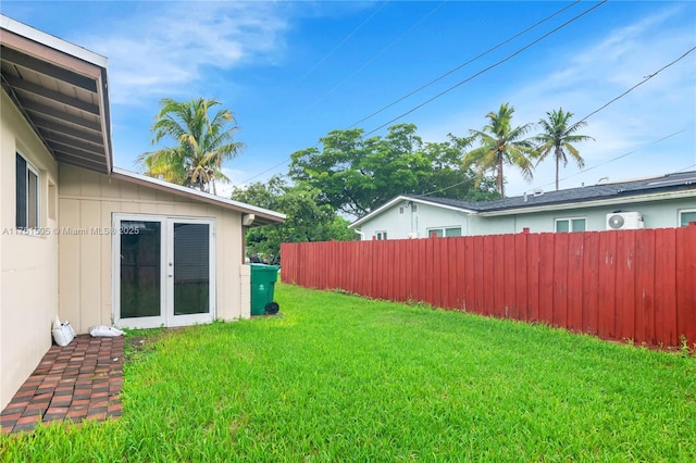 view of yard with french doors and fence