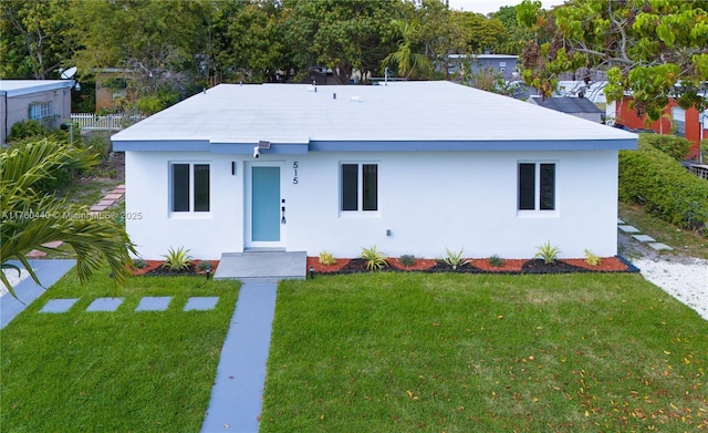 view of front facade with a front lawn, fence, and stucco siding