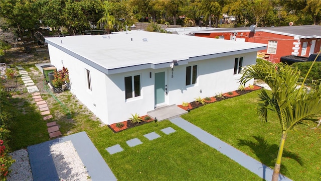 view of front of house featuring stucco siding and a front lawn