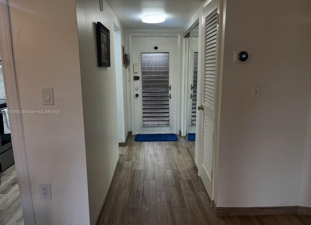 hallway with wood finished floors and baseboards