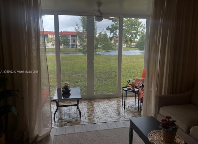 doorway with a water view and ceiling fan