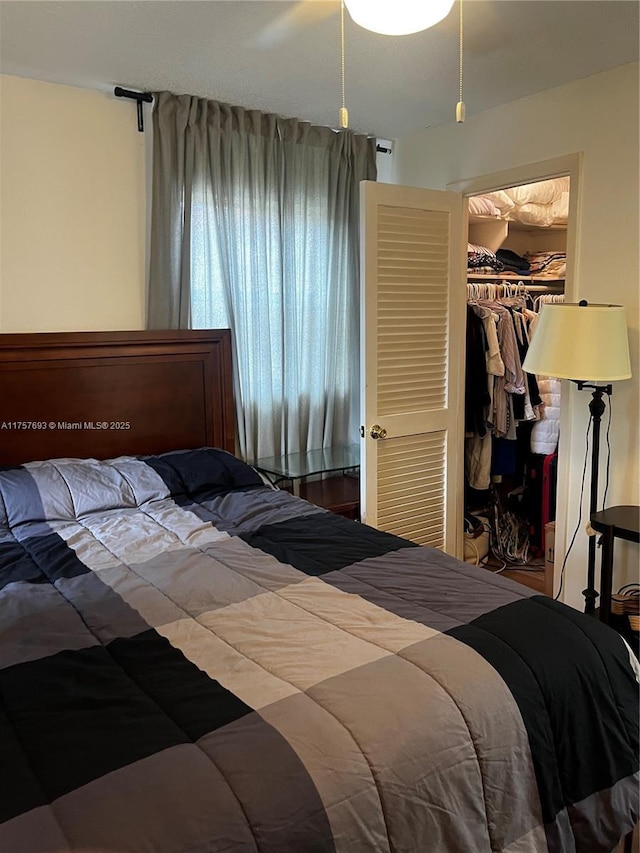 bedroom with a ceiling fan, a closet, and a walk in closet