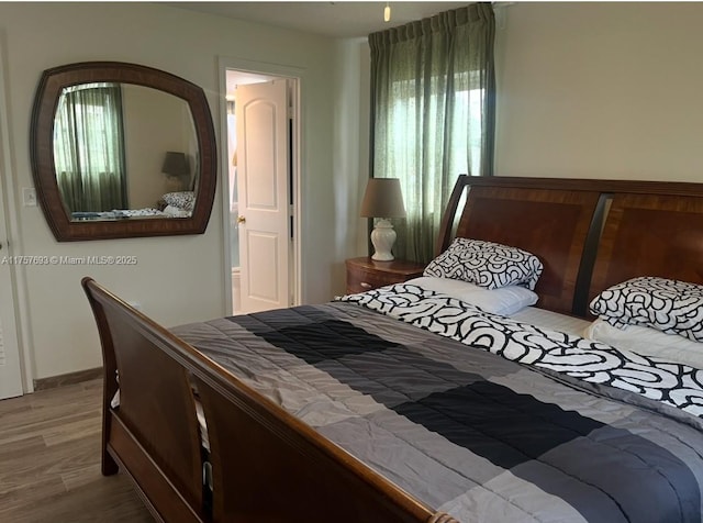 bedroom with multiple windows and wood finished floors