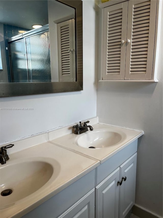 bathroom with double vanity, a stall shower, and a sink
