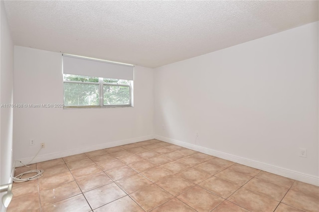 empty room featuring baseboards and a textured ceiling