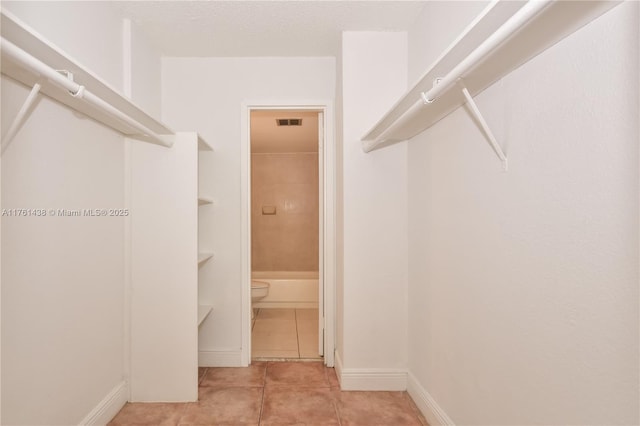 spacious closet with light tile patterned floors and visible vents