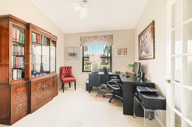 carpeted office featuring lofted ceiling and baseboards