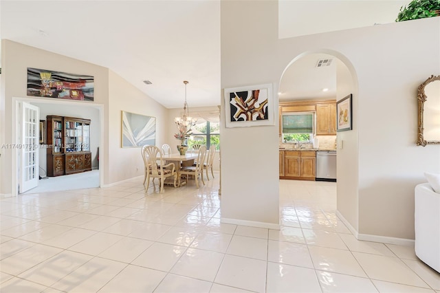 dining area featuring visible vents, baseboards, light tile patterned flooring, arched walkways, and a chandelier