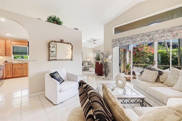 living area featuring light tile patterned flooring, arched walkways, and vaulted ceiling