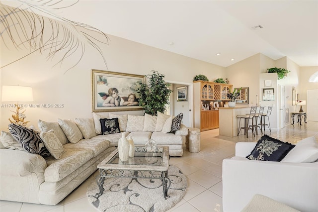 living area with light tile patterned flooring, visible vents, and vaulted ceiling