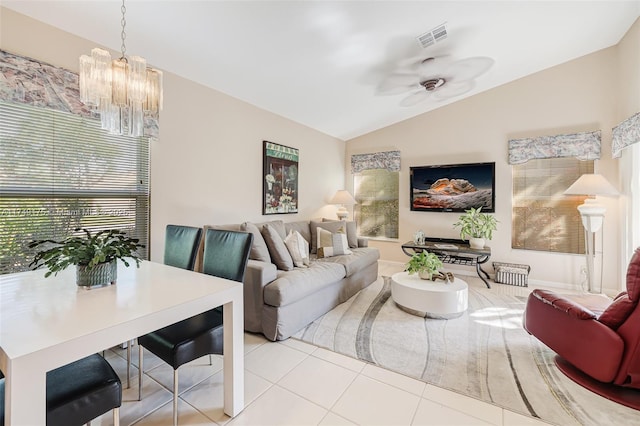 tiled living area featuring vaulted ceiling, ceiling fan with notable chandelier, visible vents, and a wealth of natural light