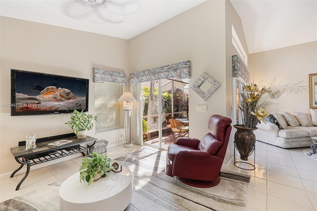 living area featuring tile patterned floors, a ceiling fan, and baseboards